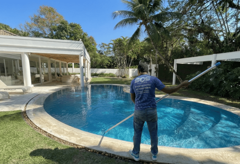 Piscineiro realizando limpeza e manutenção mensal de piscina em Jacarepaguá - S.O.S Piscinas.