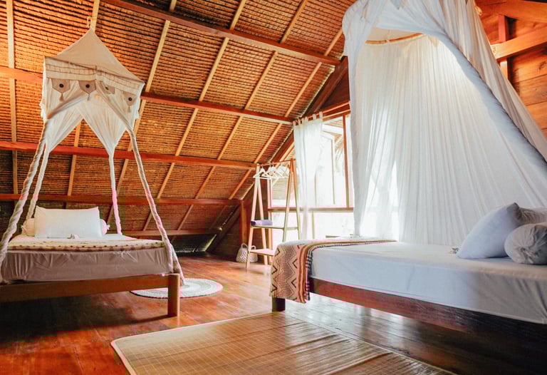 Cozy double bedroom in Toska Surf House with canopy bed and wooden interiors