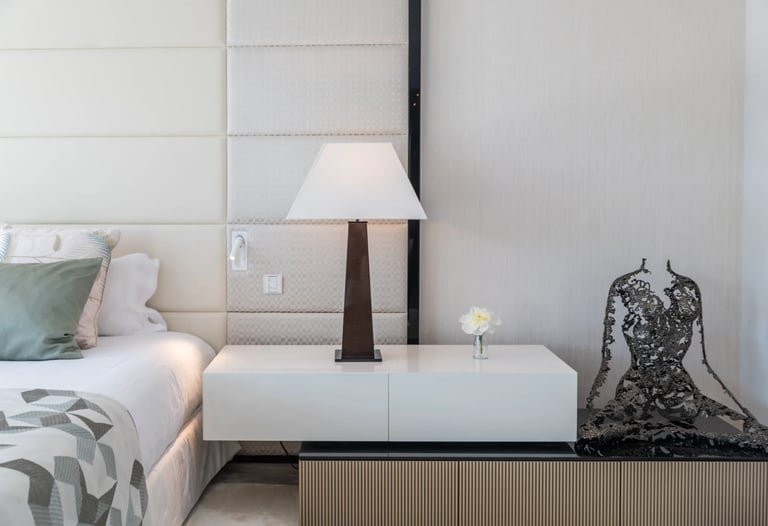 Modern bedside table with lamp and sculpture at Villa Serenity