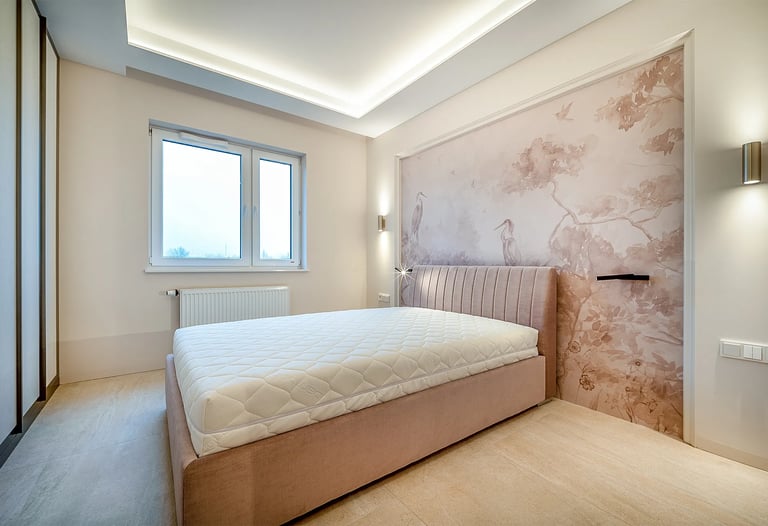 Sypialnia z łóżkiem i materacem, tapicerowany zagłówek, ściana z tapetą w ptaki, okno i oświetlenie 