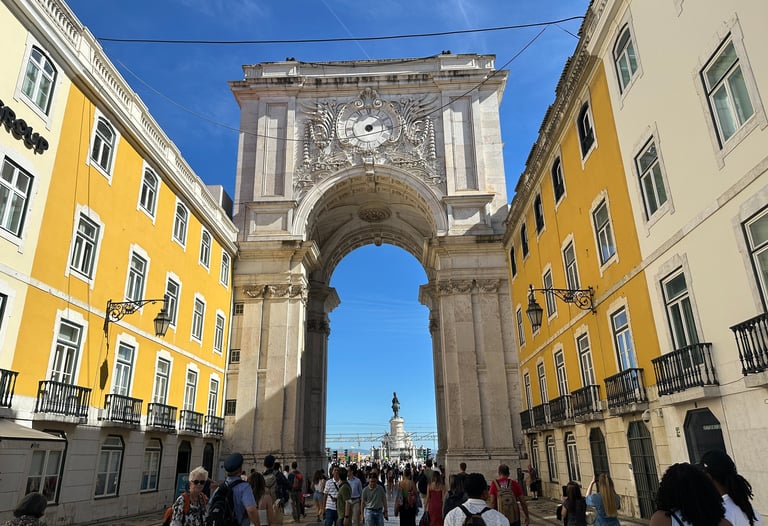 Duas paredes amarelas, conectadas por um arco de concreto que conta com uma escultura no topo 