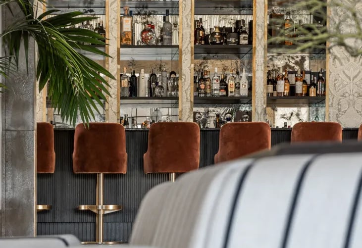 Cocktail bar at Villa La Gratitud with custom cabinetry and velvet seating