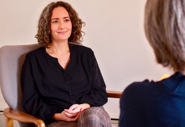 Female therapist with a relaxed and calm demeanor sits across from client 