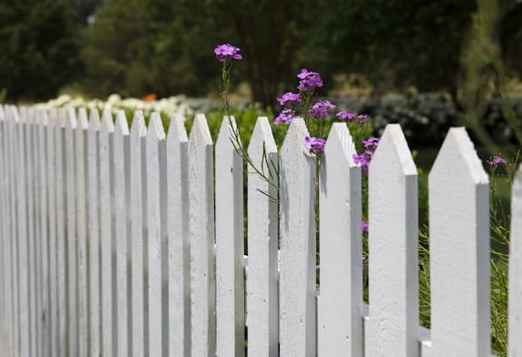 a tall wooden compost fence