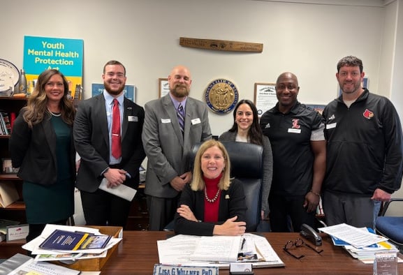 a group of people standing around a table with papers and papers