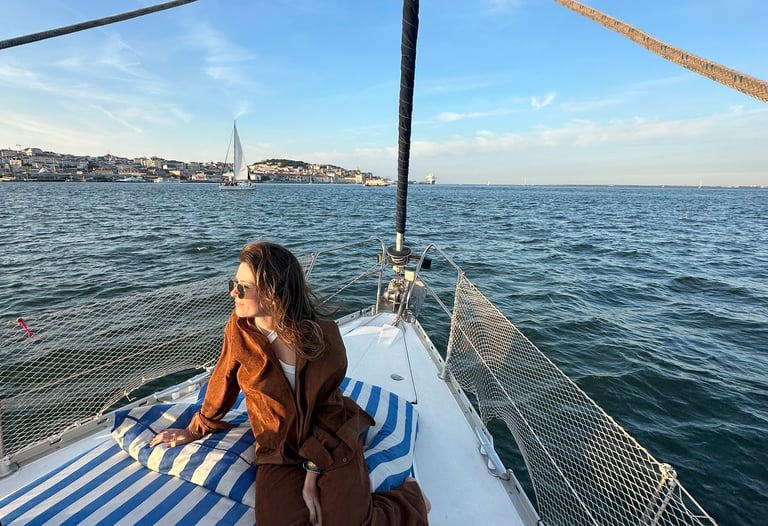 Pessoa sentada na ponta do barco, com a agua ao fundo