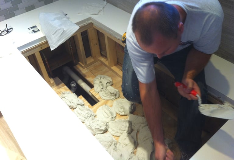 Remodeling project with tile installer leveling and setting floor for soaking bathtub