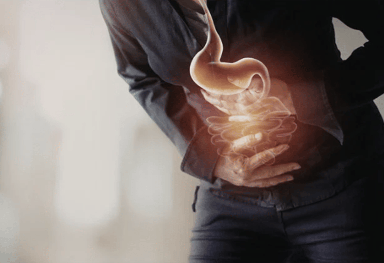 Person clutching abdomen with glowing stomach and intestines illustration showing digestive pain