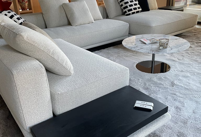 Canapé d’angle gris clair moderne avec table basse en marbre dans un intérieur de salon luxueux.