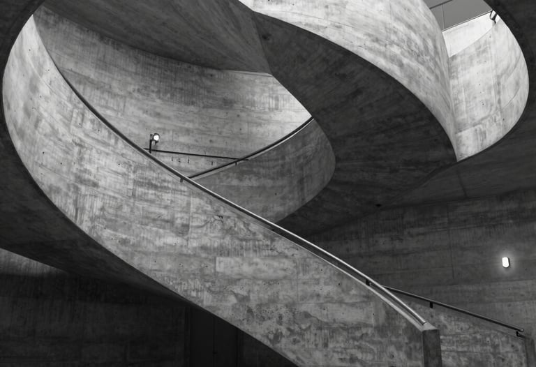 A black and white architectural shot of a spiral concrete staircase in a modern museum. Cinematic shadows and highlights. Dramatic perspective. Western European minimalist style.