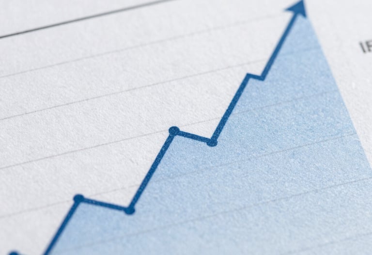 Macro photography of a financial report showing positive growth curves. The image is clean, sharp, and uses a professional palette of blues and grays.