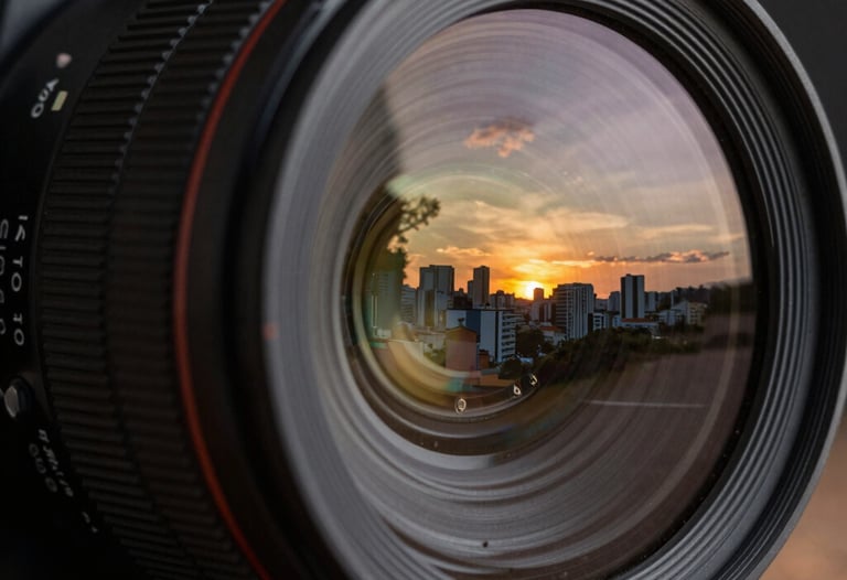 Close-up of a high-end camera lens reflecting a sunset scene in a Brazilian city. The image highlights the intersection of raw capture and technical finesse.