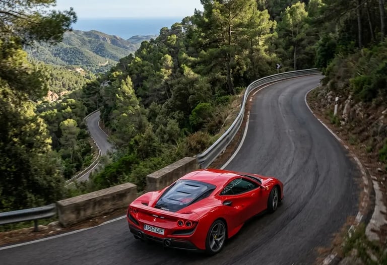 Red Ferrari driving a mountain switchback in Garraf Massif with Mediterranean sea view