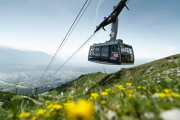 Innsbruck cable car ascending Nordkette mountain with scenic Alpine views.