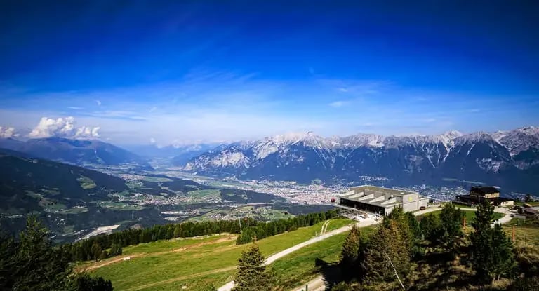 Hiking path by a mountain hut with panoramic views of the Austrian Alps.