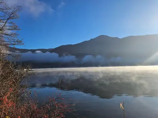 Misty morning atmosphere on Lake Zell with mountains Zell am See Austria.
