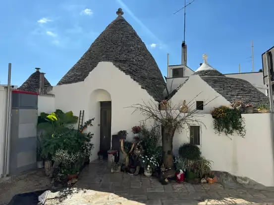 Traditional trullo dwelling with conical limestone roof and whitewashed walls in Alberobello