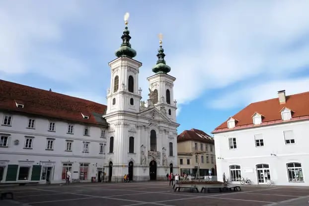 Beautiful white church architecture in the heart of Graz old town, showcasing the city's UNESCO World Heritage status.