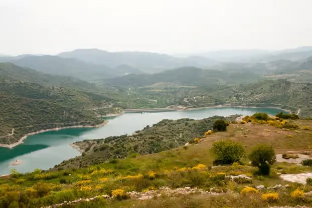 Turquoise Siurana reservoir surrounded by green hills in Priorat Catalonia
