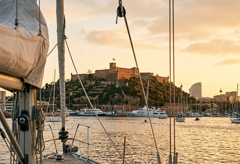 Montjuïc castle seen through yacht rigging at sunset returning to Barcelona harbour