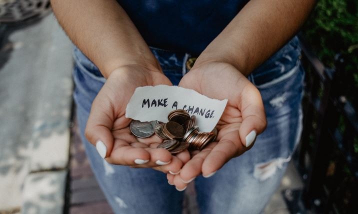 a person holding a not that says make a change