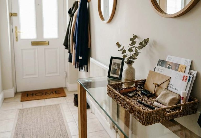 European home hallway with a small tray holding mail, keys and everyday items on a console table