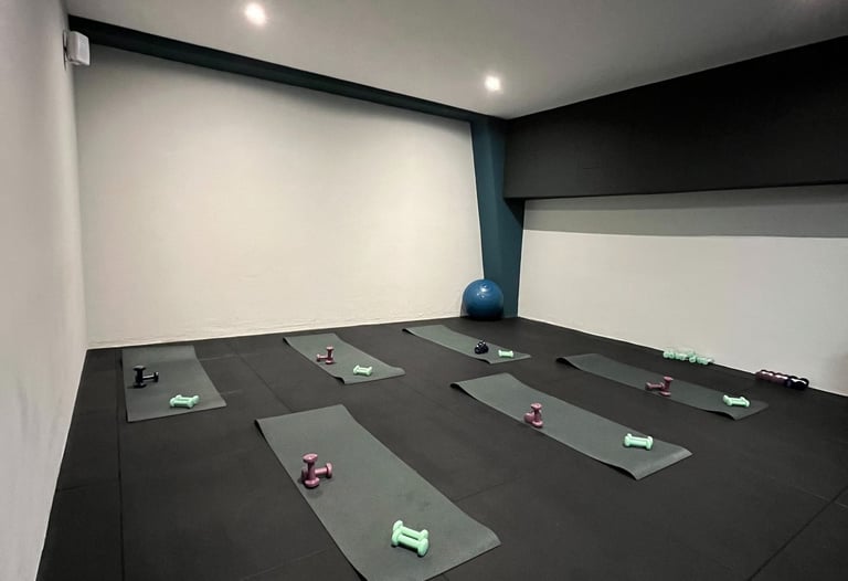 Sala fitness della palestra Move 2 Grow a Milano con tappetini, manubri e attrezzature per allenamenti di gruppo.