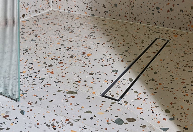 large-format terrazzo tiles in a wet room with tile in shower base