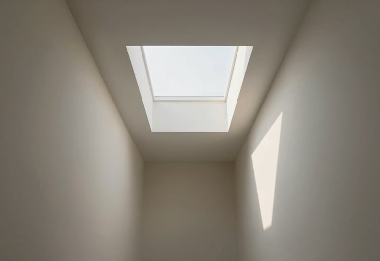 A hallway featuring clever skylights that create dramatic, warm shadows on #F9F6EE colored walls.