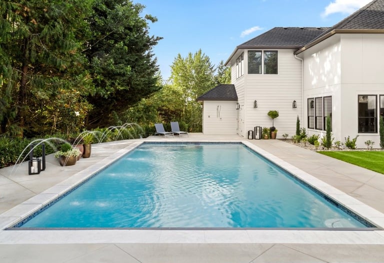 a pool with a waterfall in the concrete deck
