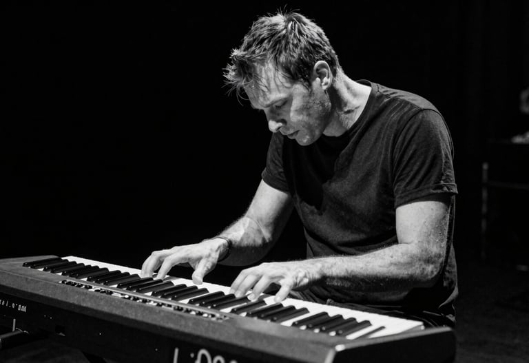 A dynamic shot of a keyboard player completely lost in the music. Elegant black and white photography, capturing raw emotion. Deep black background, off-white keys. Western European / Dutch concert.
