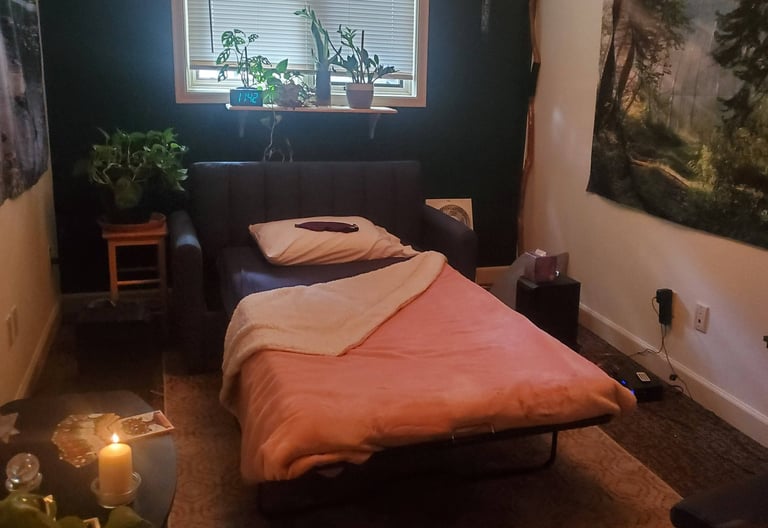 A psychedelic therapy room, set up with a bed, candles, speakers, plants and artwork