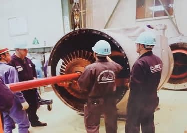 Engineers performing maintenance on a large Mitsubishi Turbocharger