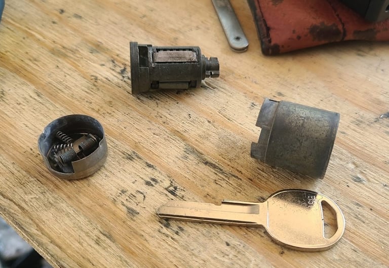 Ignition pieces taken apart beside a key representing ignition repair locksmith service in Weaverville, NC