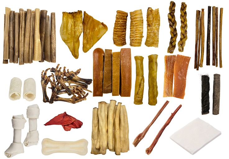 Variety of natural dog treats and rawhide chews including bully sticks, pig ears, and chicken feet.