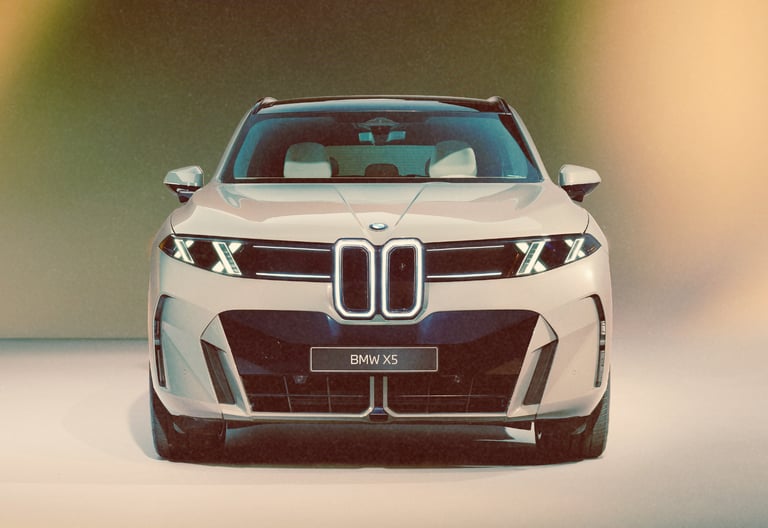 Front view of a silver BMW X5 luxury SUV concept featuring a modern illuminated kidney grille and sleek LED headlights.