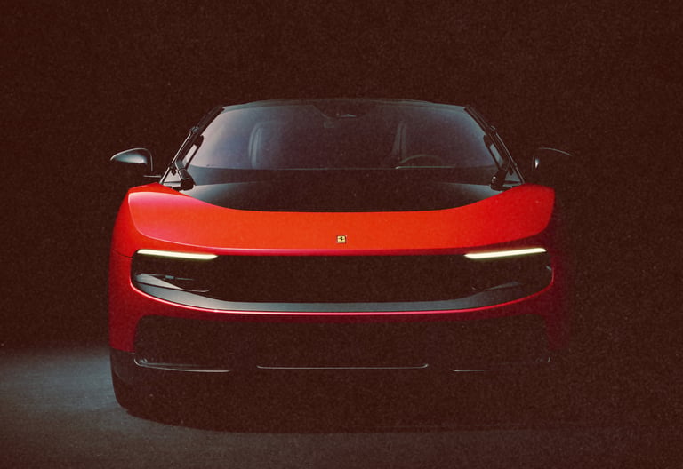 Front view of a sleek red Ferrari luxury sports car with headlights on against a dark background.