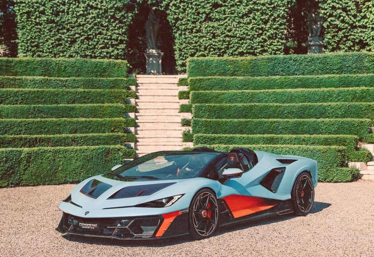 A light blue Lamborghini  luxury supercar parked in front of terraced green hedges and stone stairs.
