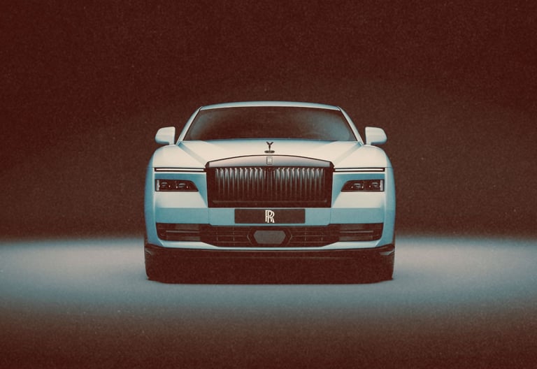 Front view of a white Rolls-Royce luxury sedan featuring its signature grille and Spirit of Ecstasy hood ornament.