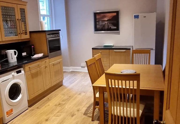 a kitchen at The kitchen at Gourock Seaview Holiday Let with a washing machine and dinner table