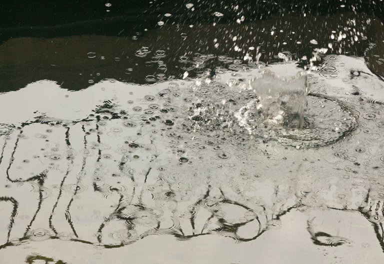 Monochromatic body of water reflecting a steel railing.