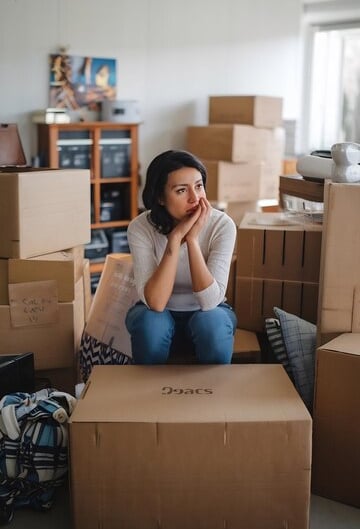 sad woman sitting surrounded by boxes