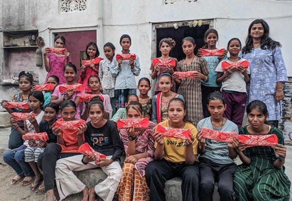 Schoolgirls holding up a Hanaru reusable sanitary napkin
