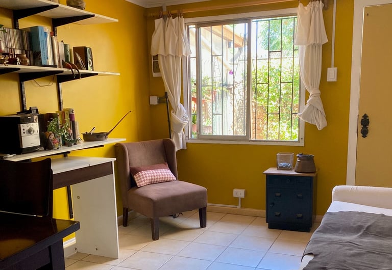 Interior de sala de estar con paredes amarillas y zona de trabajo | proyecto del Studio Atípico