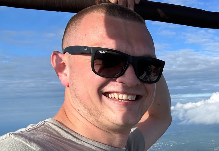 a man in sunglasses and sunglasses is smiling and holding a bat