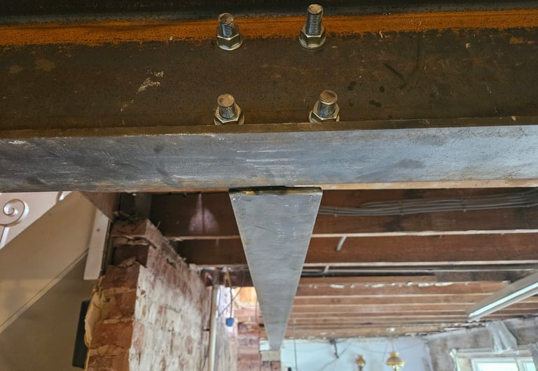 Structural steel beam secured with heavy-duty bolts and nuts for home renovation support.