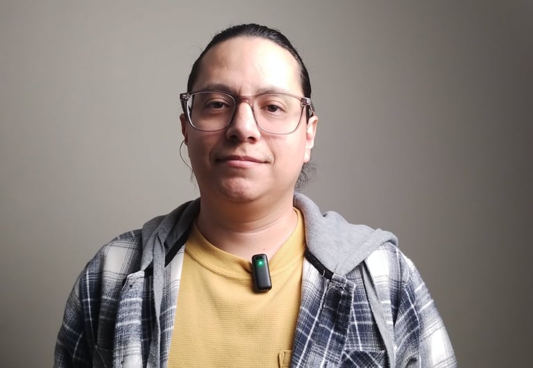 un hombre llamado jose Francisco con camisa de cuadros y un microfono