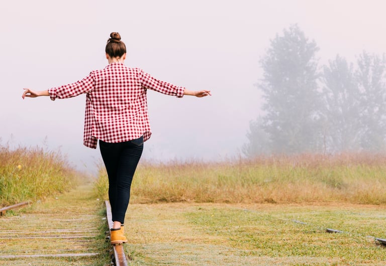 a woman walking on a railroad track