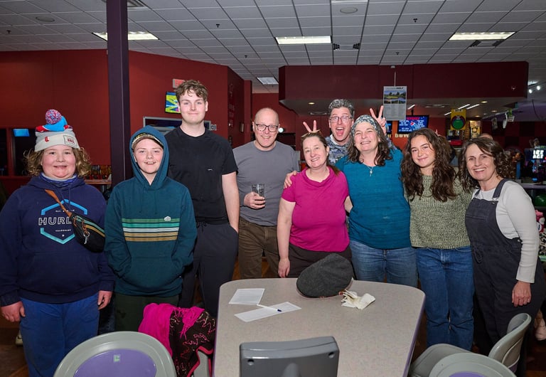 a group of people standing around a table in a bowling alley
