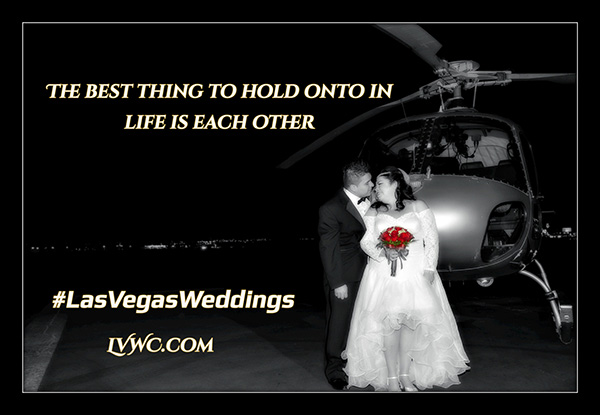 a bride and groom standing in front of a helicopter